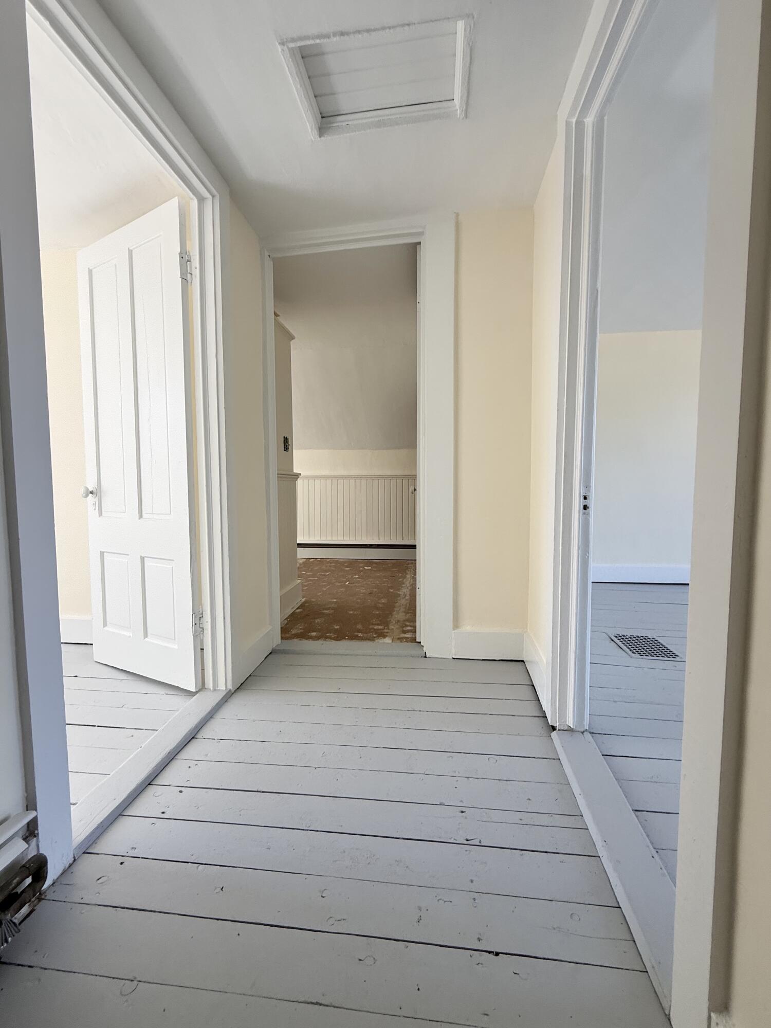 Upstairs hall way has freshly painted pine floors and walls.