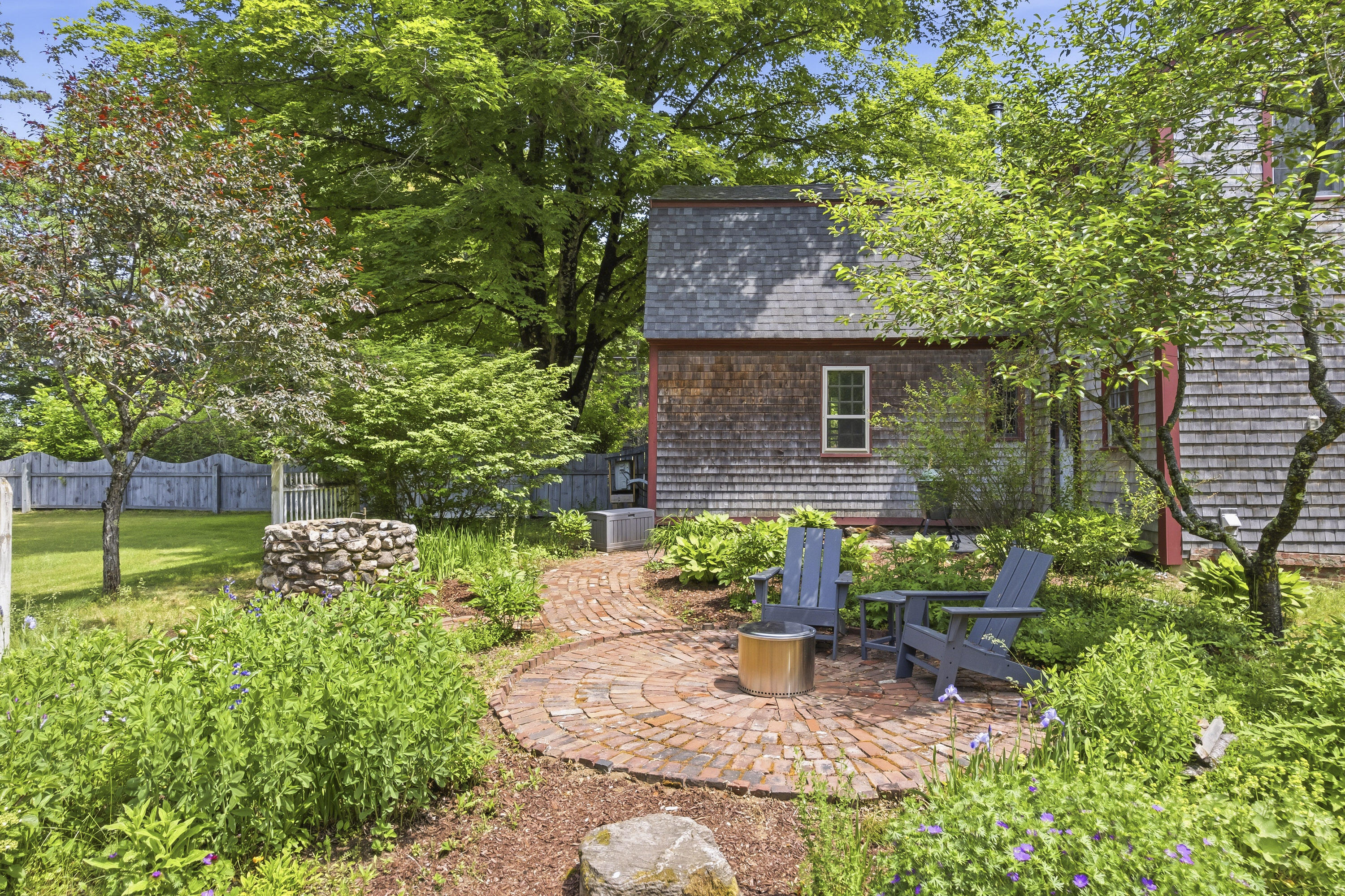 Inviting patio surrounded by mature perennial gardens