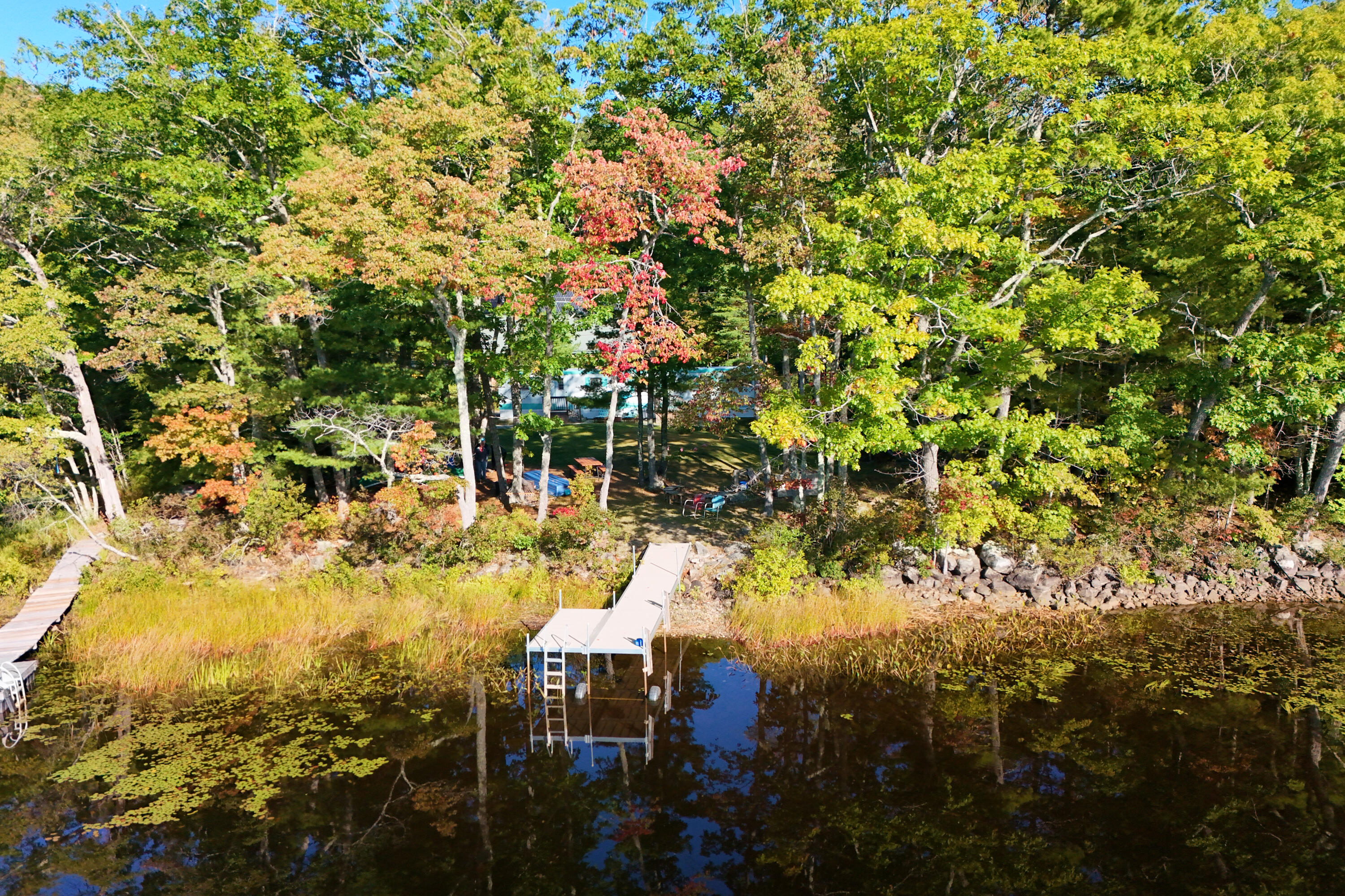 Tucked away at the end of a quiet country lane, is a rare waterfront escape with nearly 160 feet of frontage on peaceful Dyer Long Pond. This charming getaway offers the perfect blend of simplicity and vintage character. The tastefully appointed manufactured home features a comfortable kitchen with dining nook, inviting living room, two bedrooms, and a full bath—everything you need for relaxed weekends, summer days, and memorable time by the water. Step outside and the pond is right there waiting. A fire pit, walkway, and waterfront platform make enjoying the shoreline easy, whether you're gathering around the fire at sunset, launching a kayak, fishing, or simply sitting by the water with a cup of coffee. Come discover Pinky LaRue's Secret Retreat—a special little slice of waterfront heaven waiting to become your own.